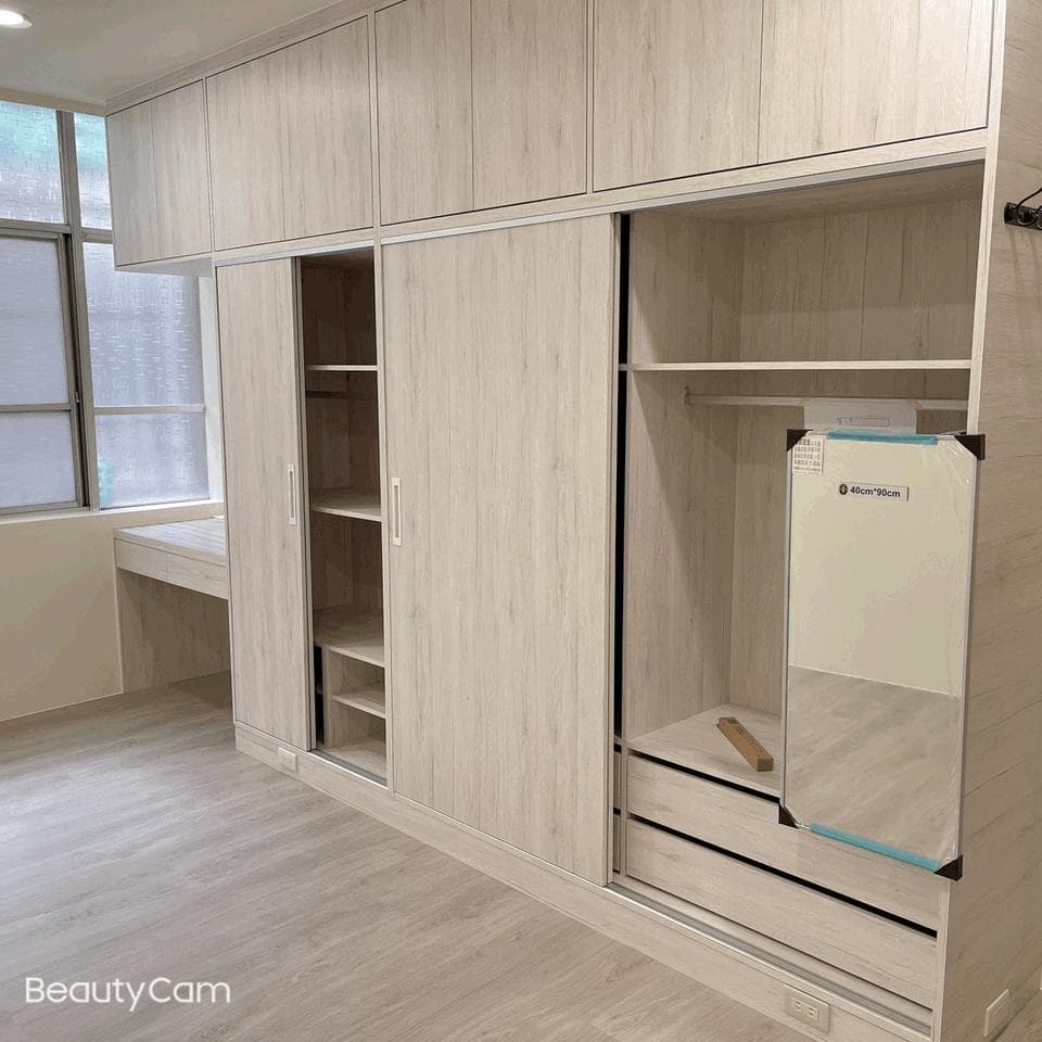 1) 照片顯示一間帶有木紋門的房間,其中一扇門是滑門,滑門裡面有一個鏡子,還有架子可以放東西