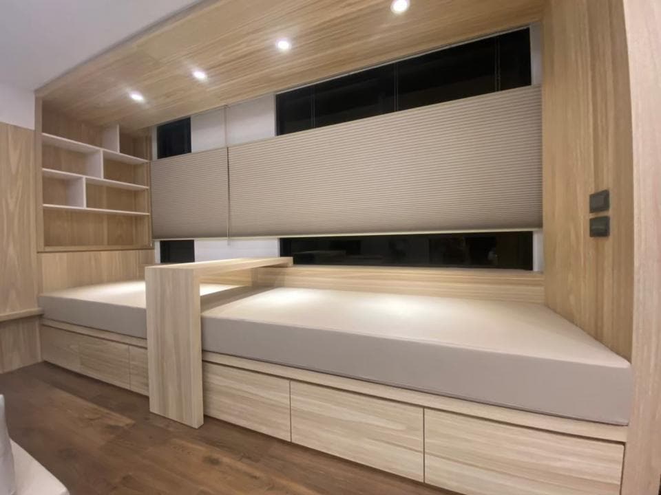 這張照片是一張床,床頭板是木頭做的,床墊是白色的,床頭板上有兩個床頭櫃。