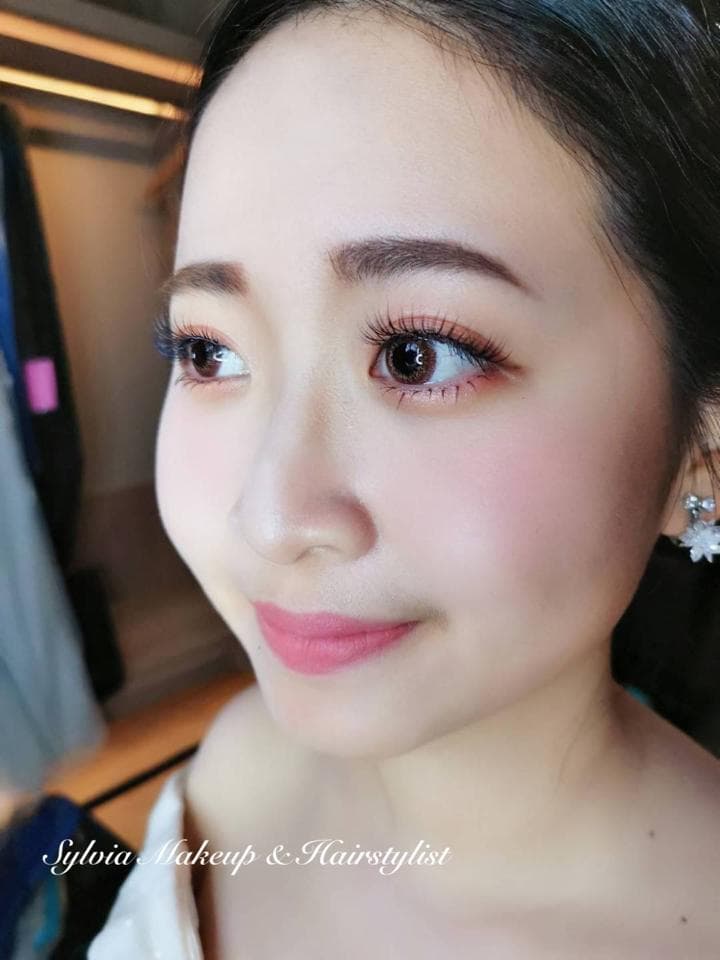 這張「新娘化妝」的照片是一個女性,她有著精緻的妝容,包括眼影、眼線和唇膏。她的眼睛看起來很明亮,她的膚色也很完美。