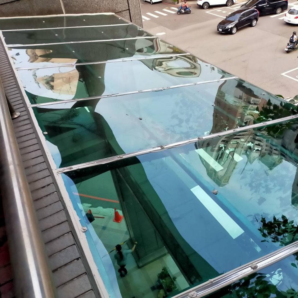 這張「玻璃屋頂」的照片是,一個建築物上的玻璃屋頂,可以看見屋頂下方空間的景象,還有天空倒影在玻璃上。