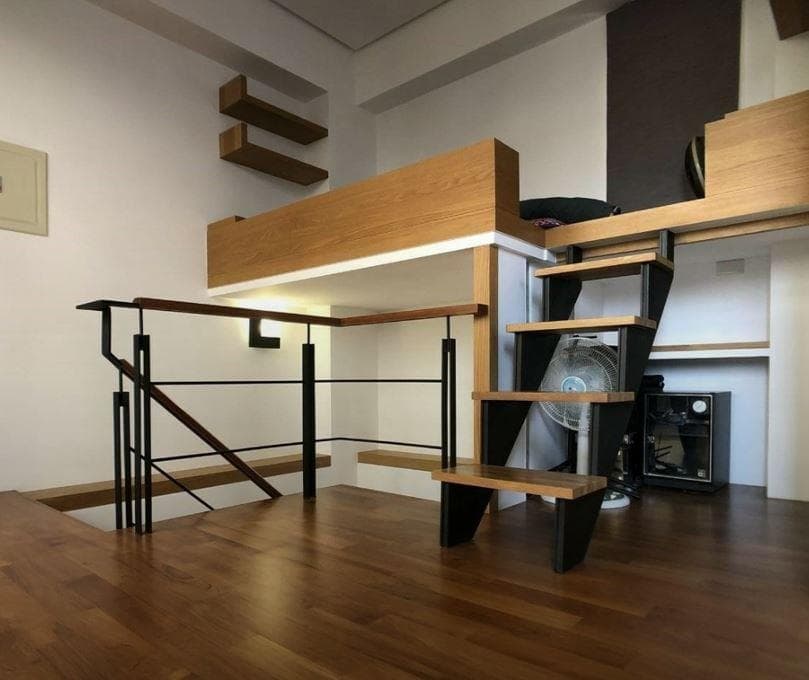 這張照片是一個現代化的樓梯,它以黑色金屬框架和木質踏板為特色,看起來既時尚又堅固。