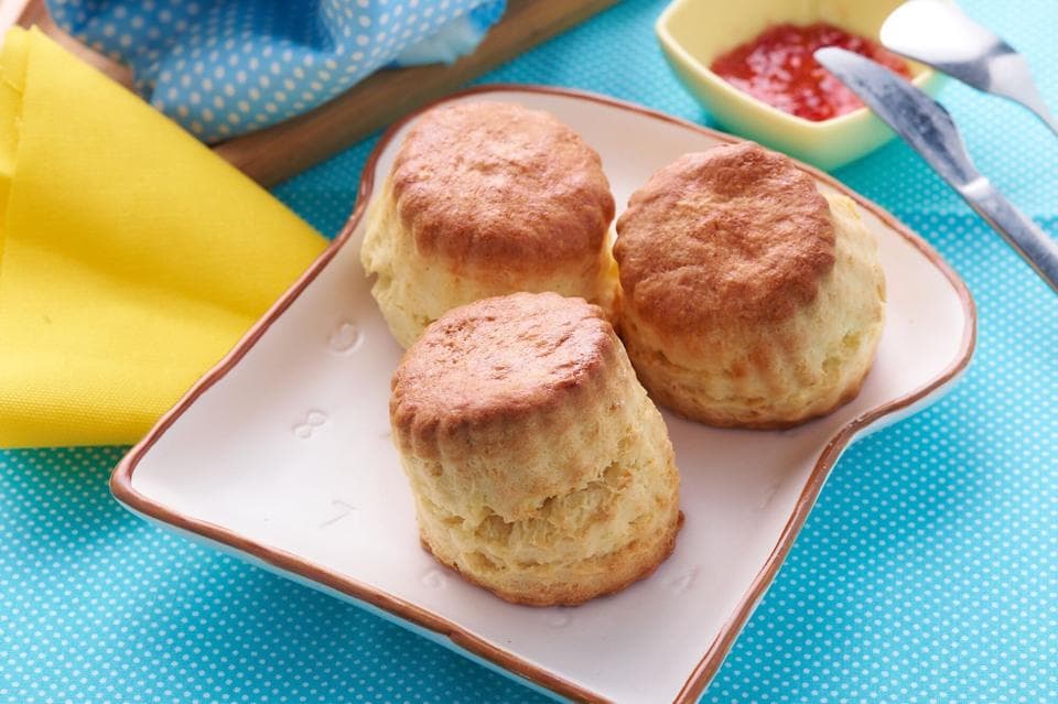 這張照片是三塊剛出爐的鬆餅,放在一個白色的盤子裡。它們看起來非常美味,而且很新鮮。