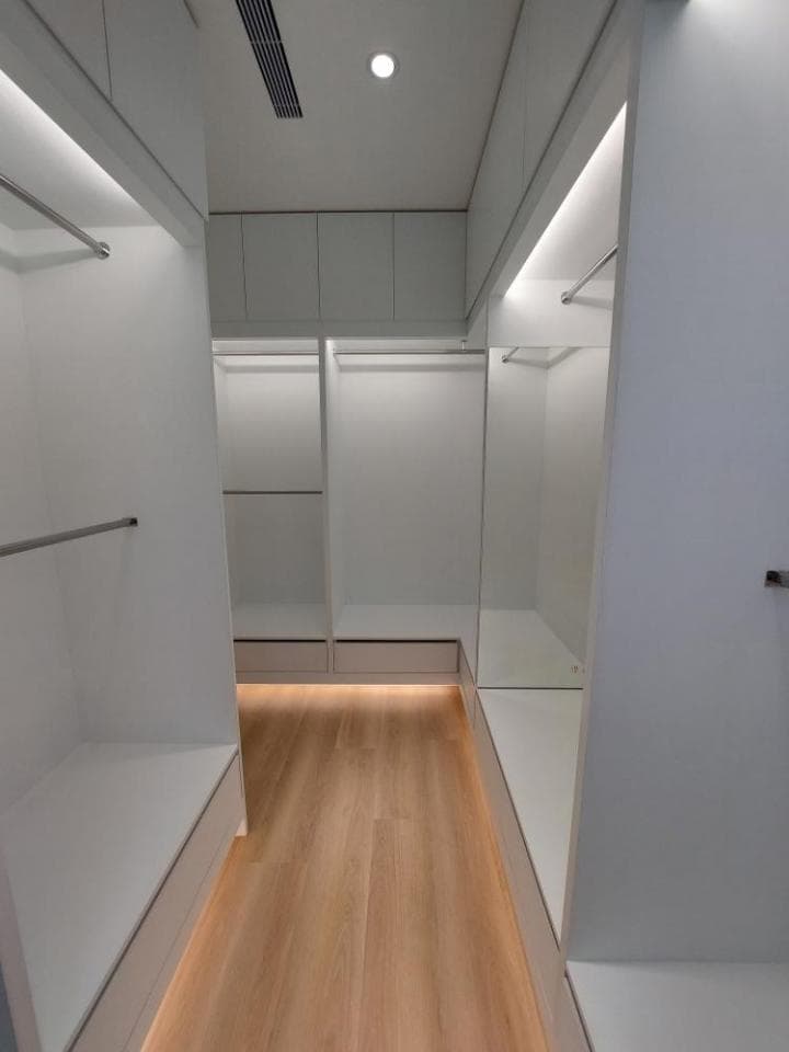 這張照片是一個現代化的衣帽間,最重要的是木質地板,它散發著溫暖的光芒,讓整個空間顯得更加舒適和優雅。