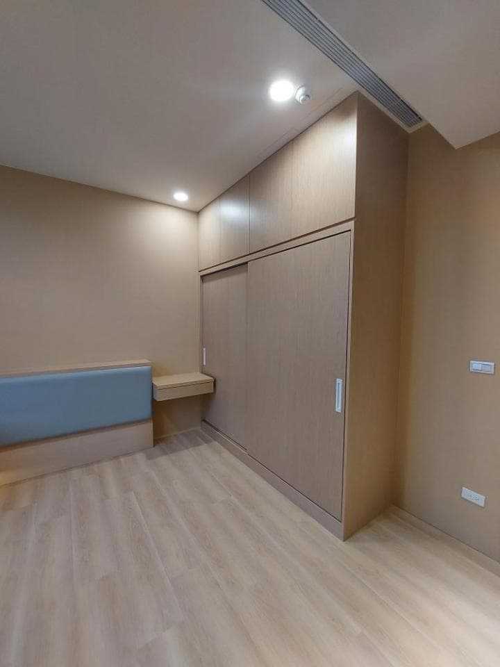 這張照片是一個房間,最顯眼的部分是房間右側的木質滑門衣櫃,它採用簡約的設計,與房間的整體風格相呼應。