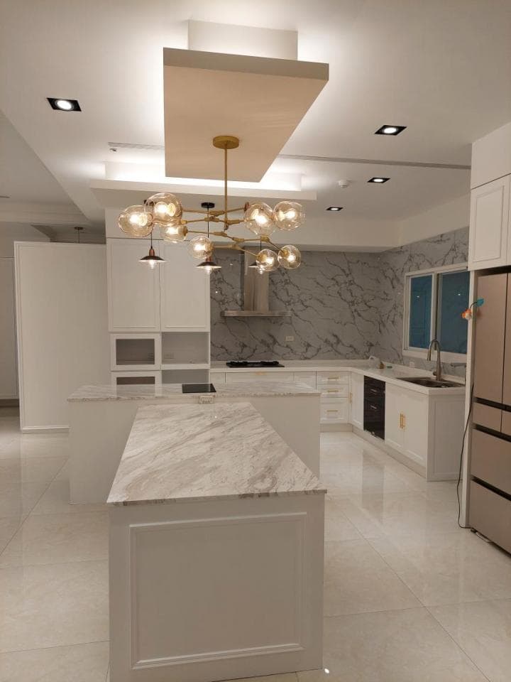 這張照片是一個現代化的廚房,最重要的是中間的大理石中島,它帶來了寬敞和時尚的感覺。