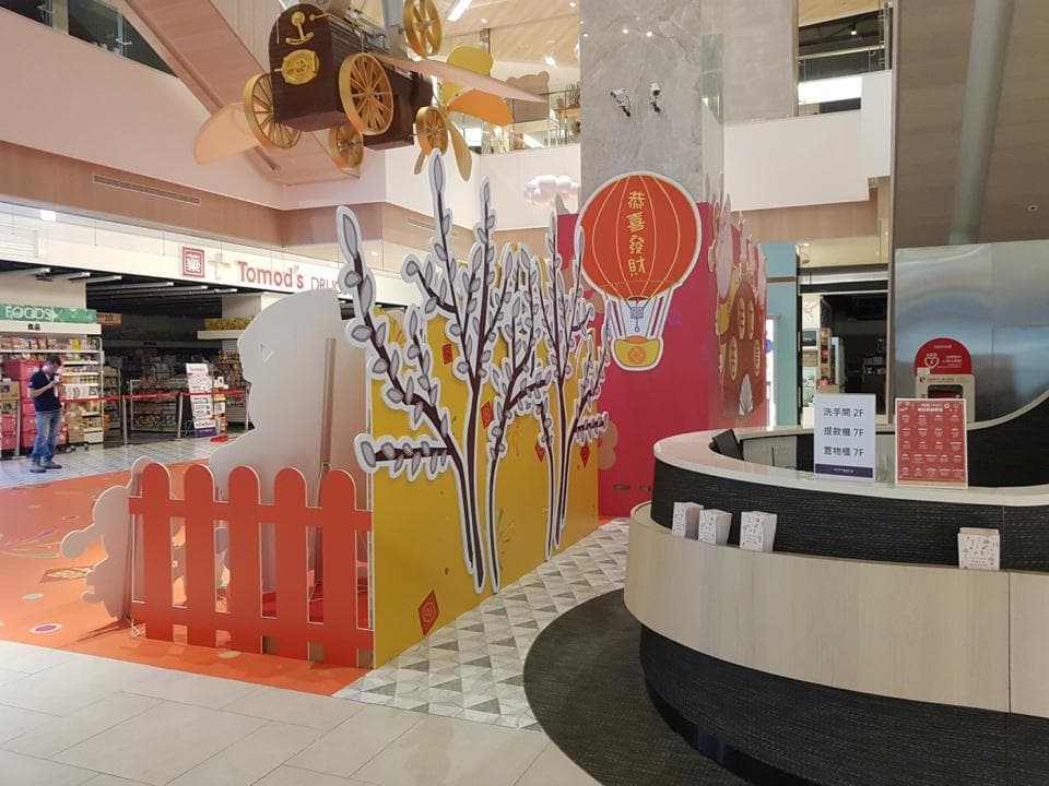 1) 這是一張在購物中心內的照片,照片中有一家商店的裝飾,裝飾以紅色的燈籠、黃色的樹和白色的柵欄為主題