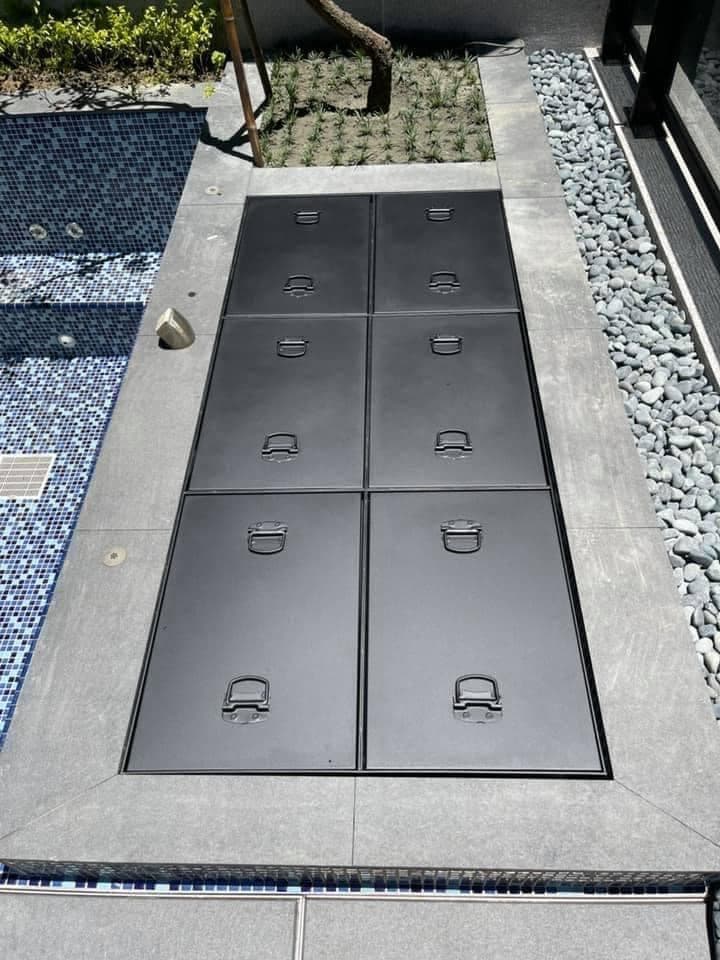 這張「游泳池」的照片是六個黑色的方形蓋板,蓋在泳池邊緣。