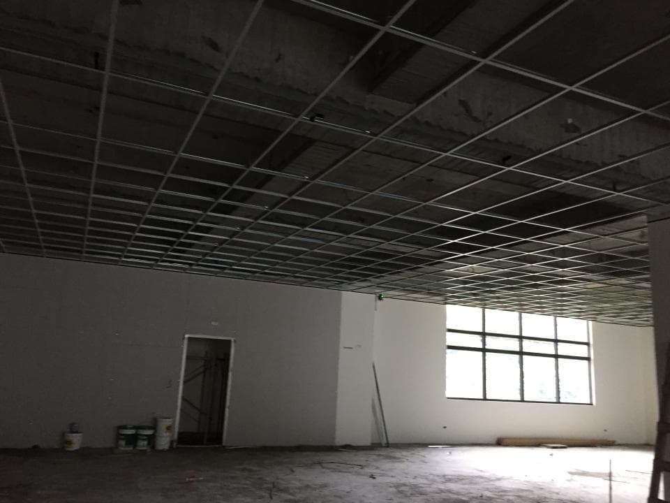 這張照片是一個正在施工的房間,最重要的是房間的天花板,它由一層網格狀的鐵架組成,看起來十分牢固。