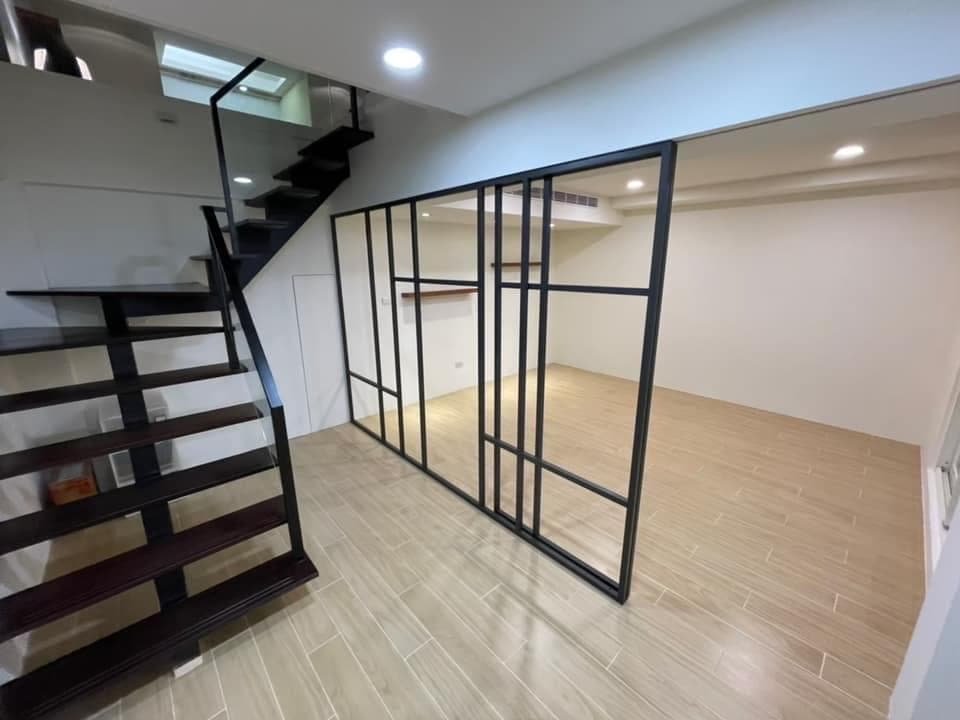 1) 照片顯示一間現代住宅的樓梯和一個玻璃門,通往另一間房間