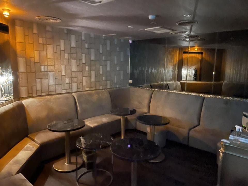 1) 照片顯示一個昏暗的房間,房間裡有沙發和桌子