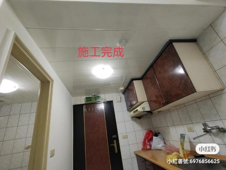 1) 這是一張浴室的照片,浴室裡有木質的櫥櫃,天花板是白色的,有一個裝修完成的標誌