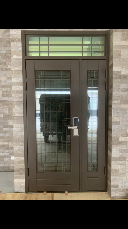 1. 照片顯示一個雙層的棕色大門,門上有玻璃窗格,並配有電子鎖