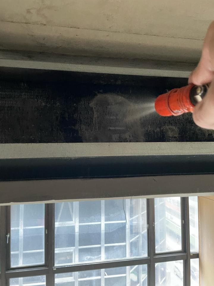 1) 照片顯示一雙手正在用紅色噴水槍清潔一個黑色的格柵