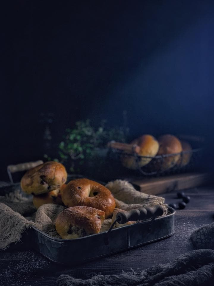 這張照片是一盤放在深色桌子上、鋪著麻布的麵包。麵包看起來很美味,而且很新鮮,讓人很想咬一口。