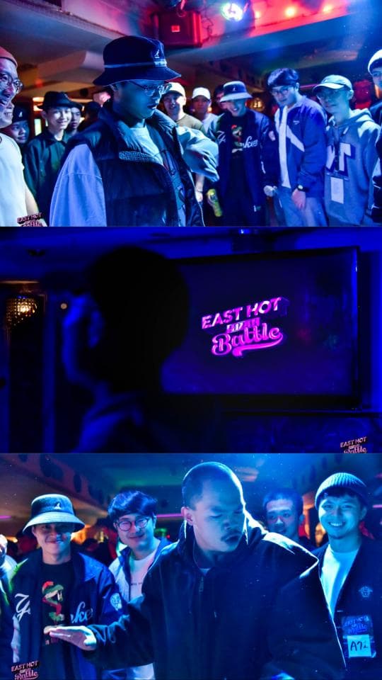 這張「嘻哈音樂」的照片是一個音樂會場景,畫面中出現了嘻哈藝人與觀眾。舞臺上有一個發光的招牌,寫著「EAST HOT FOR THE BATTLE」。