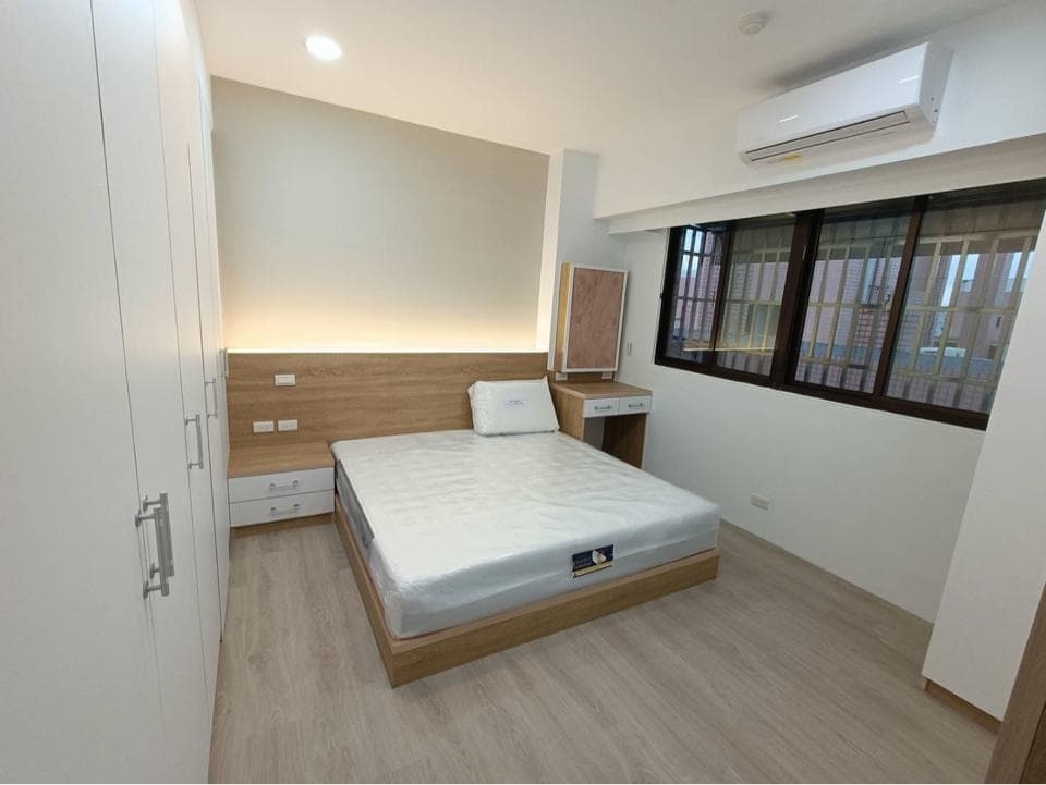 這張照片是一間臥室,最重要的是一張床,床頭板是木頭材質,床頭櫃也有木頭的元素,整體看起來溫馨又舒適。