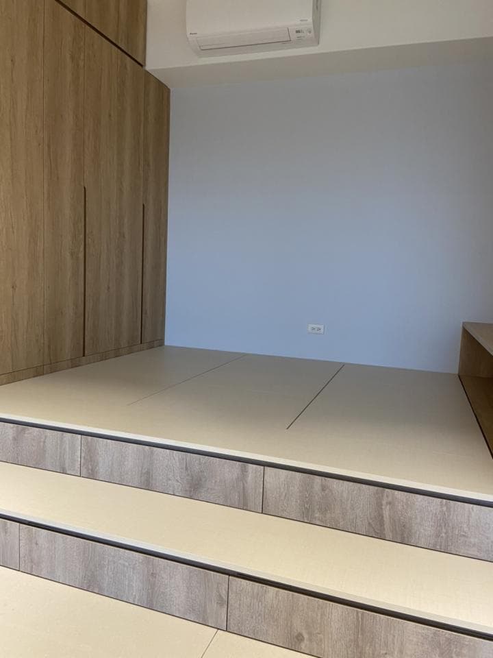 1) 照片展示了一個淺色木質地板,地板上有兩層木質階梯