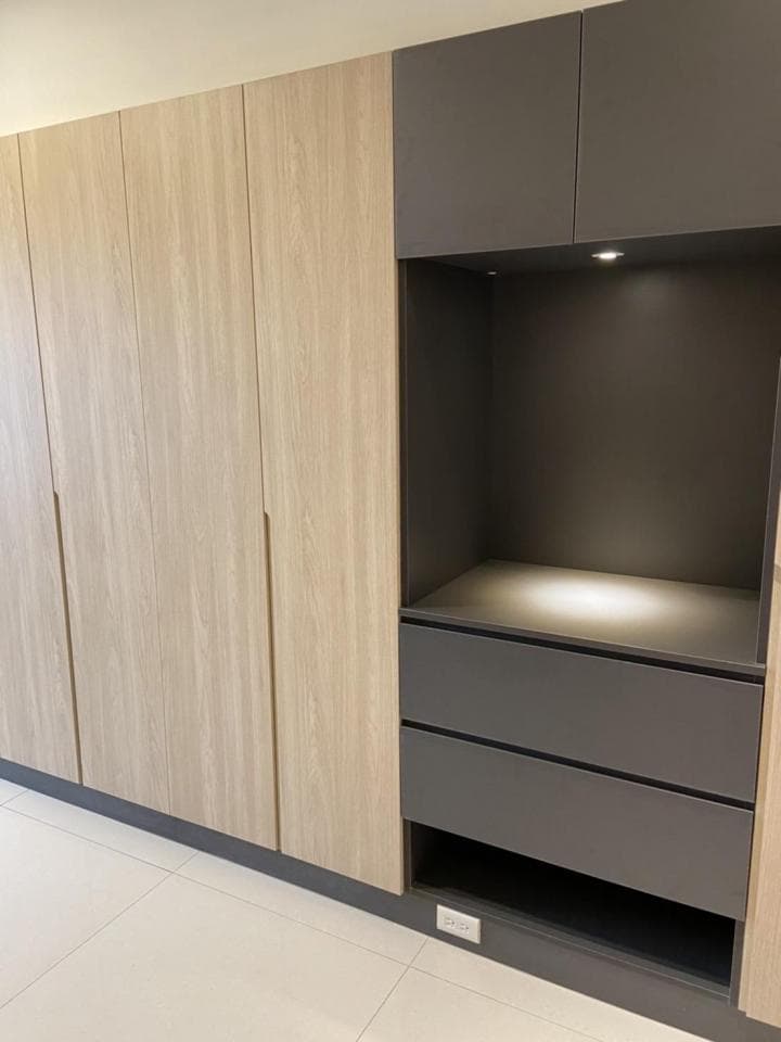 這張照片是一個衣櫃,最重要的是右邊的嵌入式櫥櫃,它有兩個抽屜和一個可以放置物品的空間,而且還有一個內嵌燈,讓整個空間看起來更加明亮。