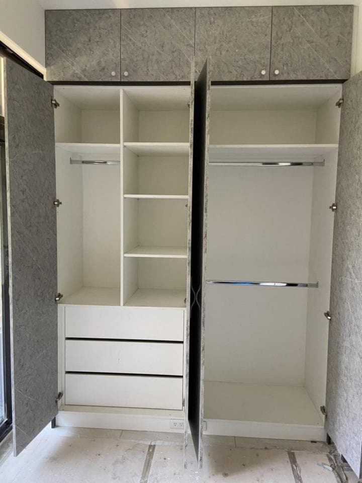 這張照片是一個現代化的衣櫃,櫃門打開,裡面有三個抽屜和三層架子,架子上方有掛衣杆,方便存放衣物。