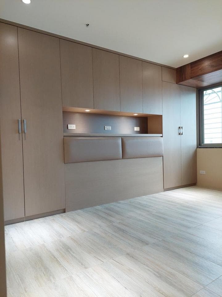 這張照片是一個現代化的臥室,地板是木紋的淺色地板,看起來很乾淨,也顯得空間很大。