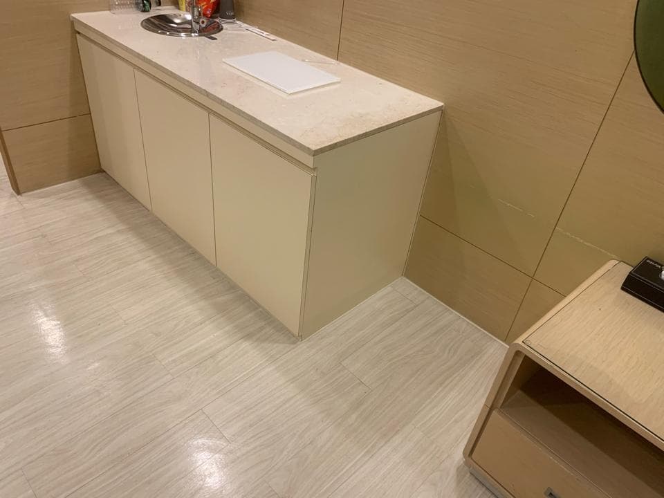 1) 照片顯示一個白色木櫃台,附有水槽和櫃子,櫃檯位於一個看起來像浴室的空間裡