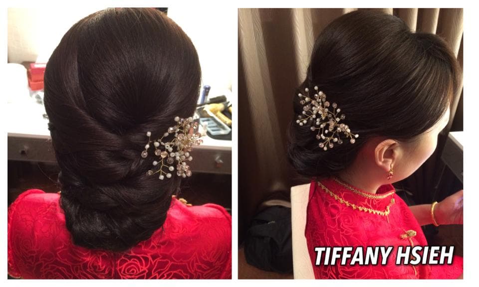 這張照片是一個女人在婚禮當天梳著一個精緻的髮型,她的頭髮被優雅地盤成一個髮髻,並用一個閃閃發光的頭飾固定。