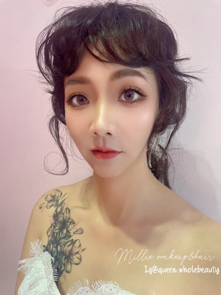 這張「婚禮造型」的照片是一位女性,她有著精緻的妝容和髮型,以及胸前精緻的刺青。