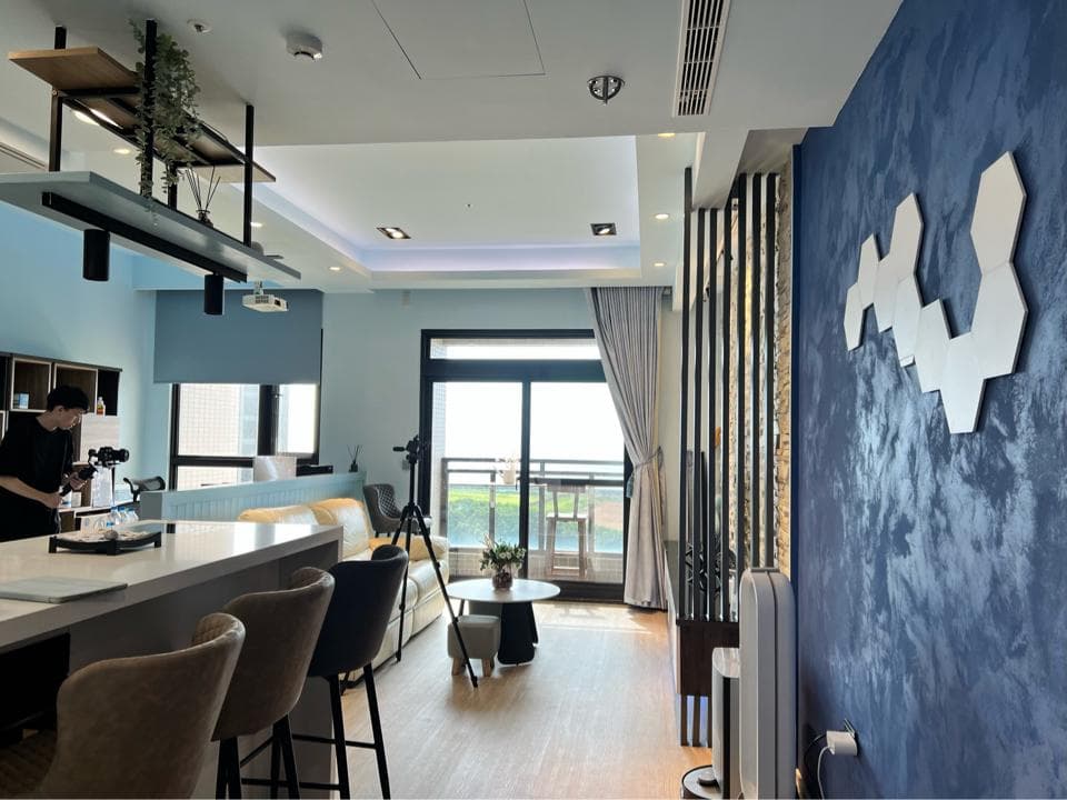 這張照片是現代化住宅的客廳,背景牆上有著裝飾性的白色蜂巢圖案,看起來很漂亮,並且很能營造舒適的空間感。