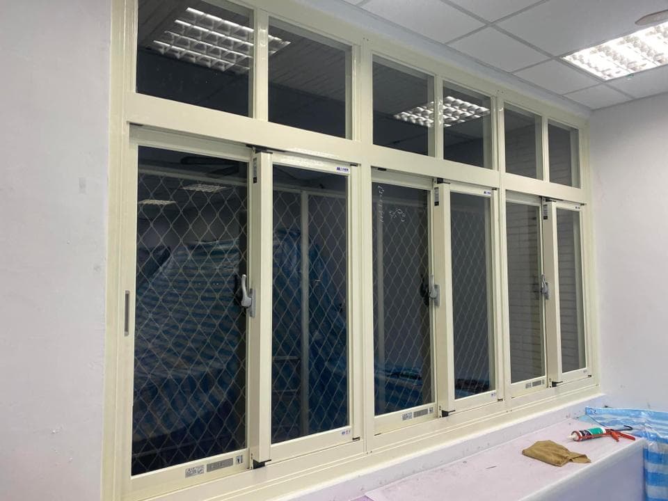 1) 照片顯示一間房間的窗戶,窗戶上裝有白色鋁窗框,窗戶上還有紗窗