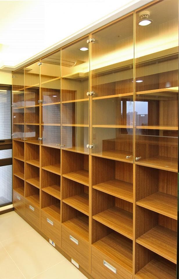 這張照片是一個現代化的書櫃,它由木頭和玻璃製成,並配有金屬把手。它有很多層,可以用來存放書籍、裝飾品和其他物品。