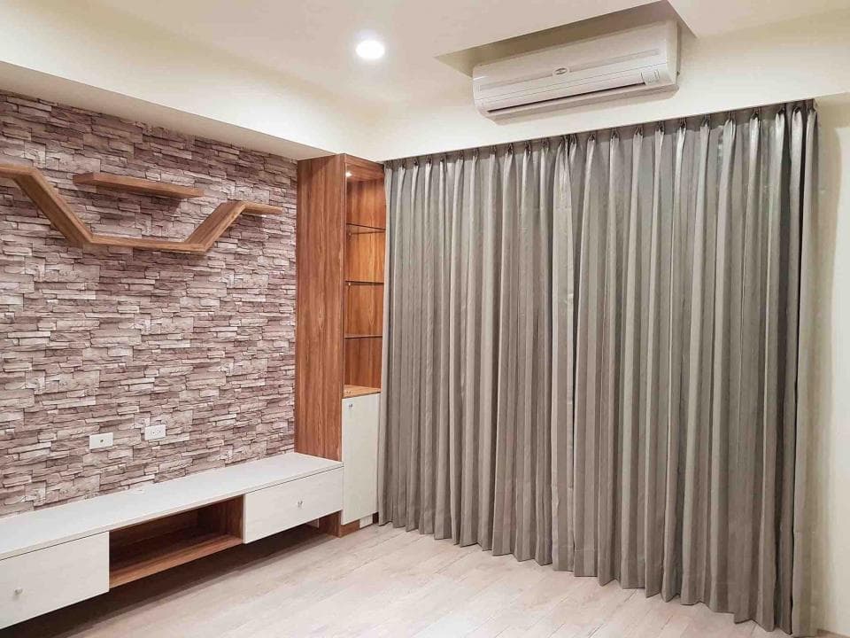 這張照片是一對新人站在一棟紅磚建築前,新郎穿著淺藍色西裝,新娘穿著白色婚紗,他們甜蜜地相視而笑。