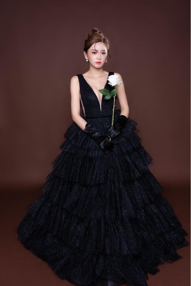 這張照片是一個穿著黑色蓬蓬裙的女孩,裙子上有許多層皺褶,看起來十分華麗。