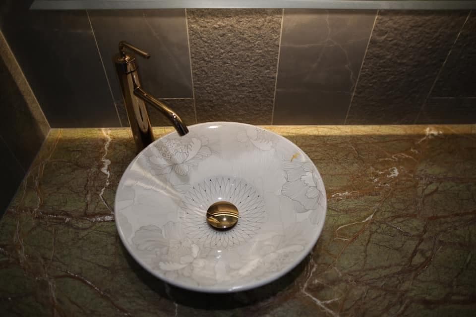 1) 照片中有一個陶瓷洗臉盆,上面有花朵圖案