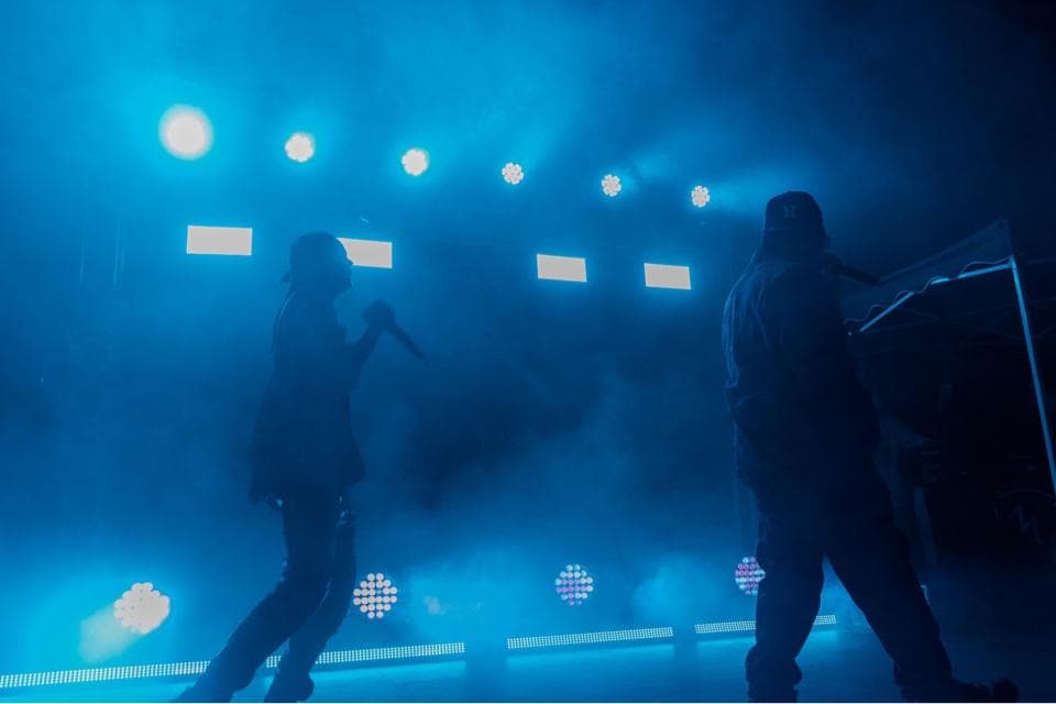 這張「演唱會」的照片是兩個歌手在舞臺上表演,燈光很炫,現場氣氛很熱烈。