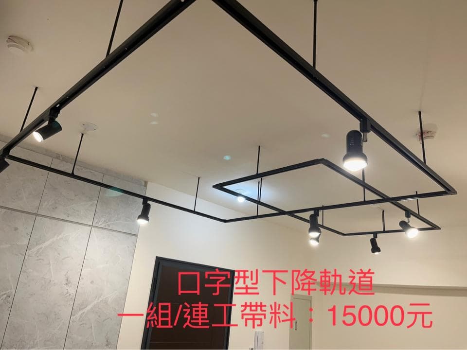 1) 照片顯示一個黑色軌道燈,安裝在天花板上的方形框架中