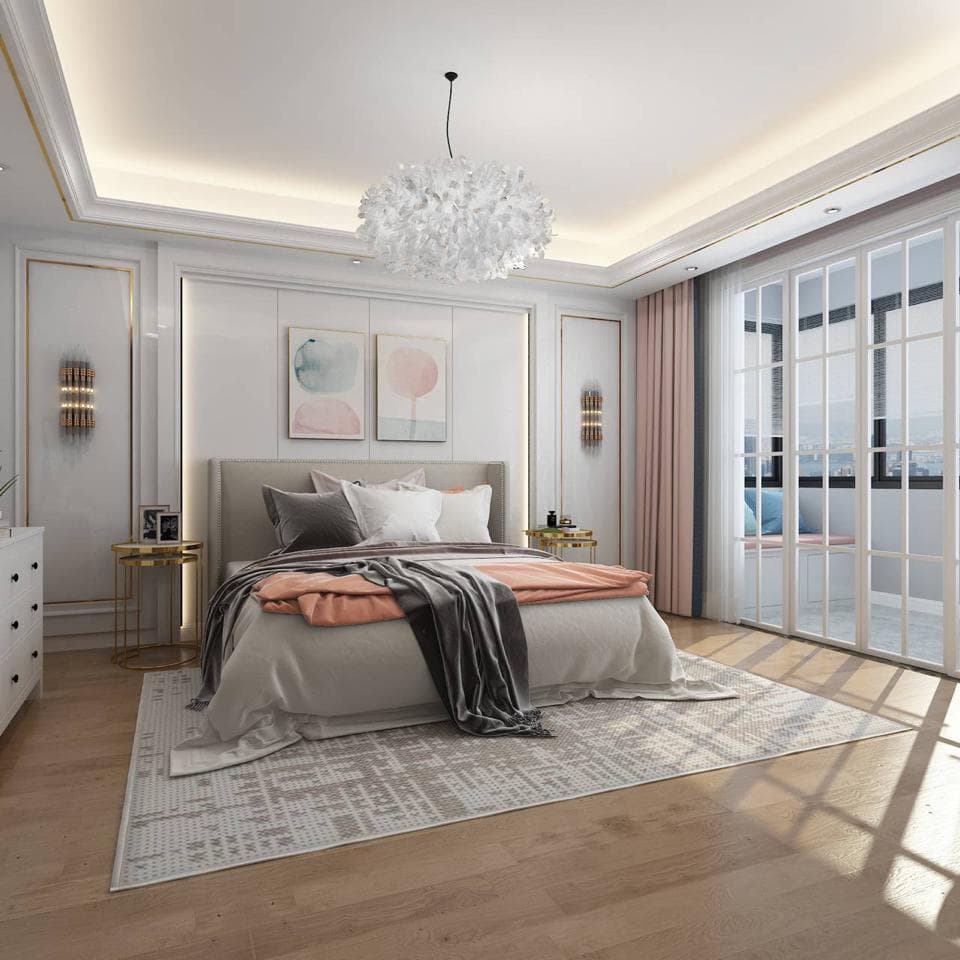 這張照片是一間臥室,房間中間有一張大床,床單和被子都是白色的,上面蓋著一條灰色的毛毯,床頭板是淺灰色的,床邊有兩個床頭櫃。床的正前方放著一個灰色的地毯,可以看出房間整體的裝修風格是簡約優雅的。