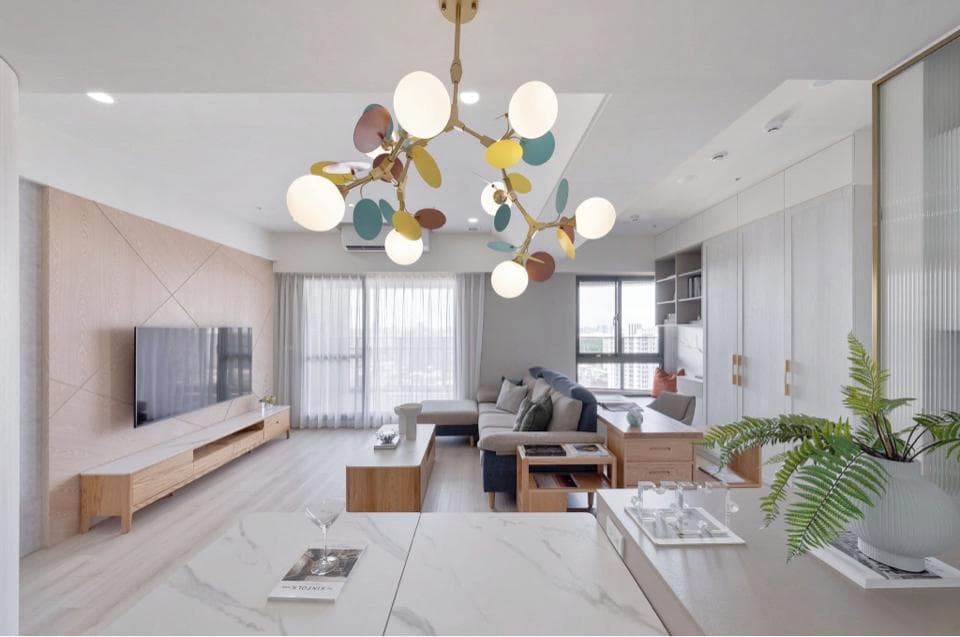 這張「現代客廳」的照片是一個明亮寬敞的空間,擁有大型落地窗、舒適的沙發和電視牆,並以簡約的木質傢俱和精緻的枝形吊燈裝飾,營造出溫馨舒適的氛圍。