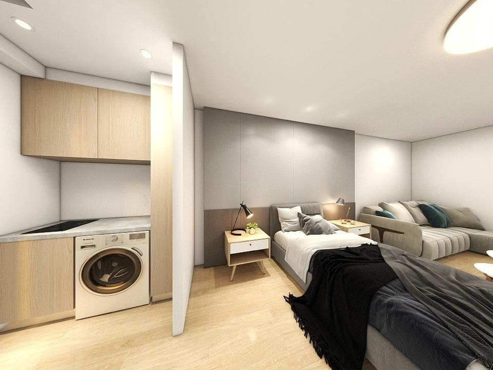 這張照片是一個現代化的小套房,最重要的是床和臥室的設計。床鋪很大,床頭板是灰色的,床單是白色的,上面放了一條黑色的毯子。床的旁邊有一個床頭櫃,上面放了一盞燈。房間的牆壁是灰色的,地板是木質的。整個房間的風格簡潔、舒適,讓人感覺很放鬆。