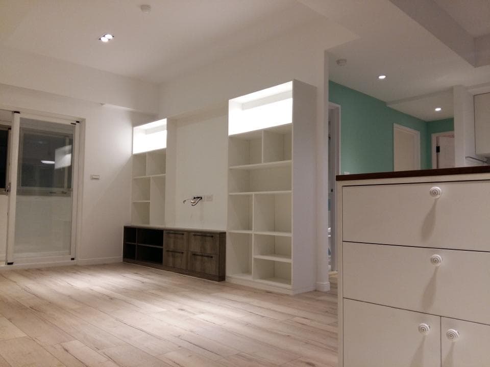 這張照片是一個現代化的居家空間,最重要的是房間裡的大型白色層架,它設計簡潔,有許多層板,可以放置各種物品,讓空間看起來更加整潔。