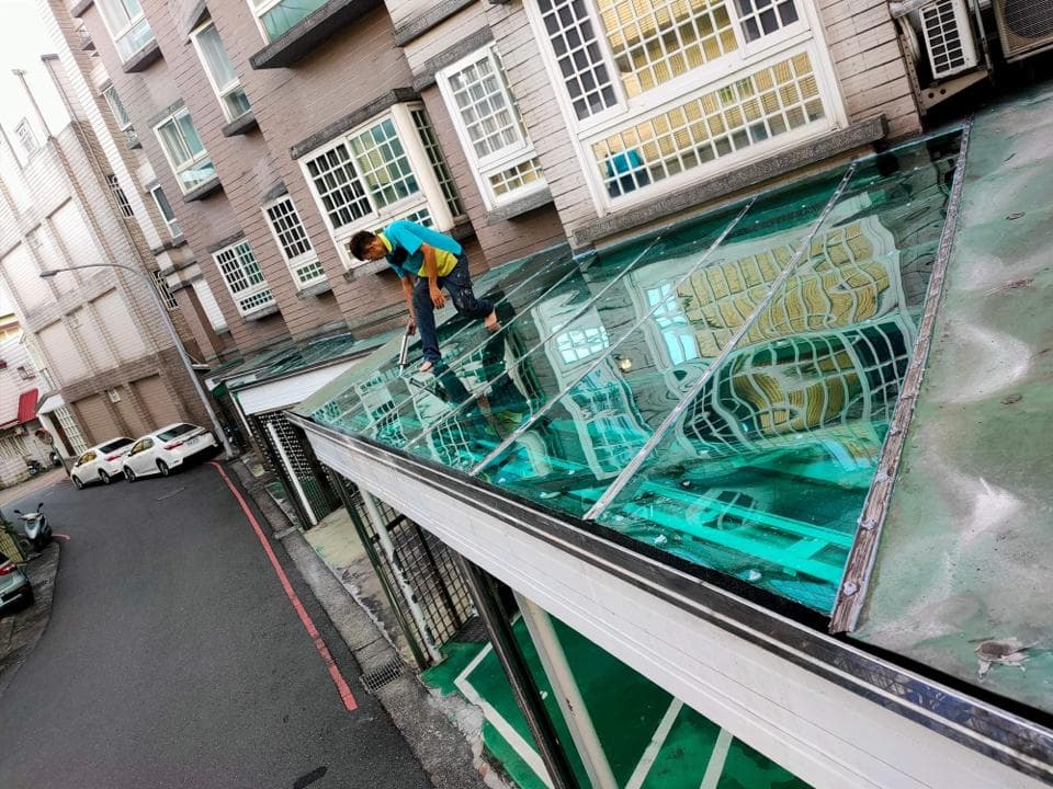 這張「玻璃屋頂」的照片是一個正在安裝玻璃屋頂的建築物。照片中可以看到工人正在安裝屋頂的玻璃,還有建築物外觀。