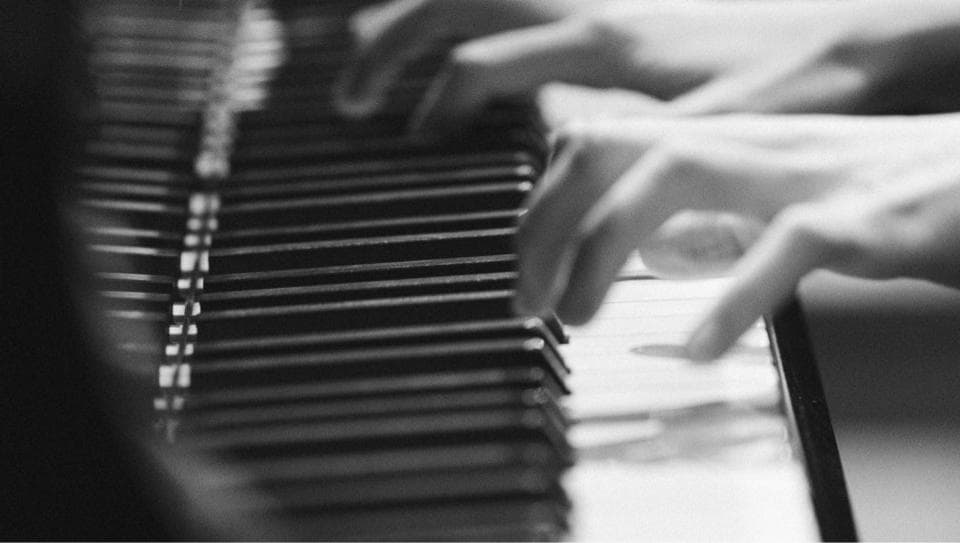 這張「鋼琴」的照片是一雙手在彈奏鋼琴。