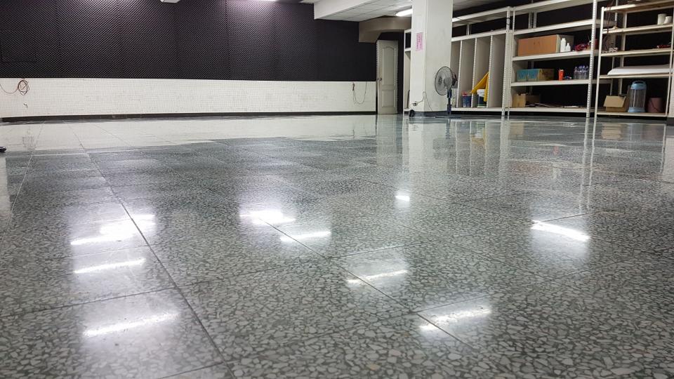 這張照片是一間空間寬敞的房間,地板是拋光的水泥,非常光亮乾淨。