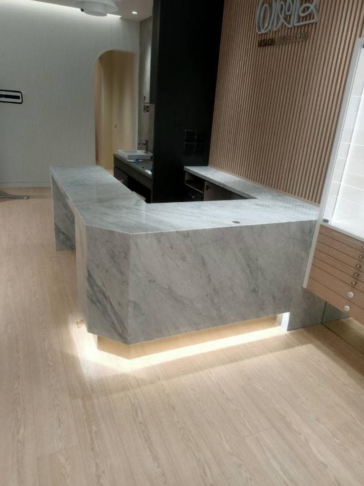 這張照片是 一個現代化的櫃檯,有著白色的大理石台面,看起來乾淨又奢華。