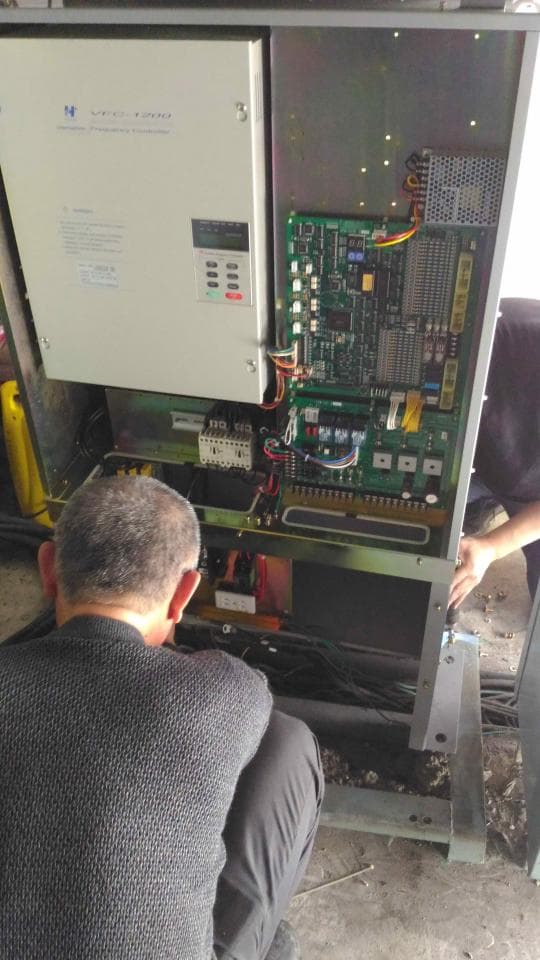 1) 這張照片顯示一個男人站在一個大型的電氣設備旁邊