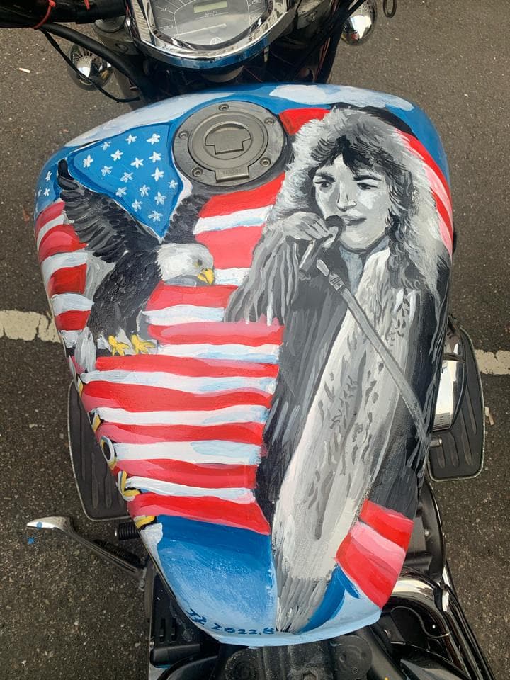 這張「摩托車油箱」的照片是油箱上繪有美國國旗、鷹和一個戴著耳機的人。