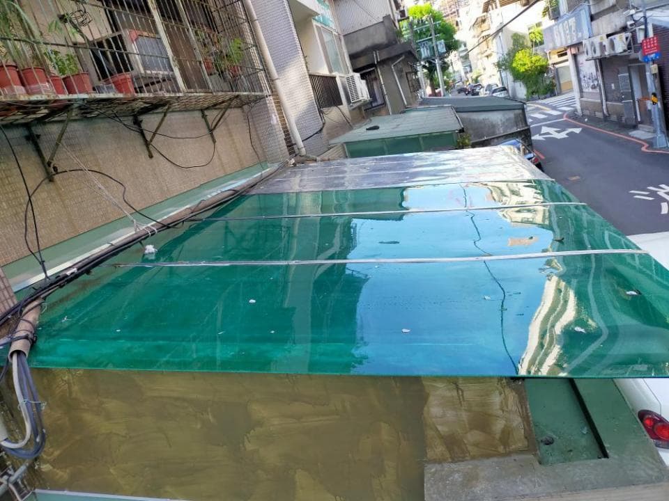 這張照片是一個綠色的透明屋頂,上面有幾根線條。屋頂看起來很新,非常乾淨,光線可以透過它照射進來。