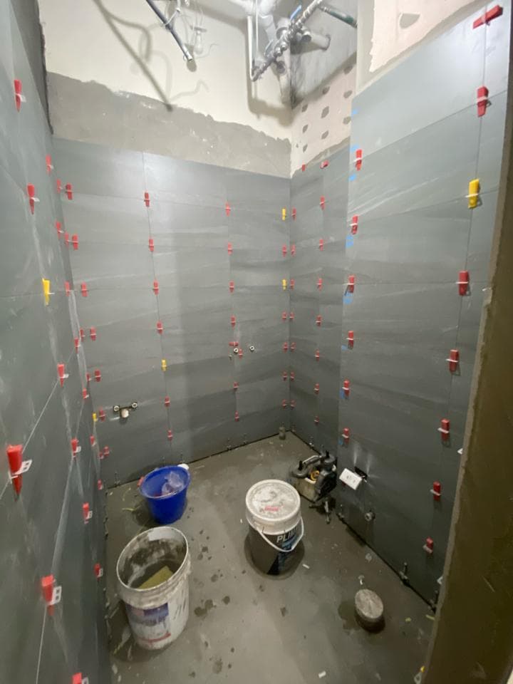 這張照片是廚房的一部分,最重要的是一個白色的流理台,上面有一個水槽和一個水龍頭。流理台下有三個白色的櫥櫃,每個櫥櫃上都有一個金色的把手。地板上有黑白相間的方格瓷磚。