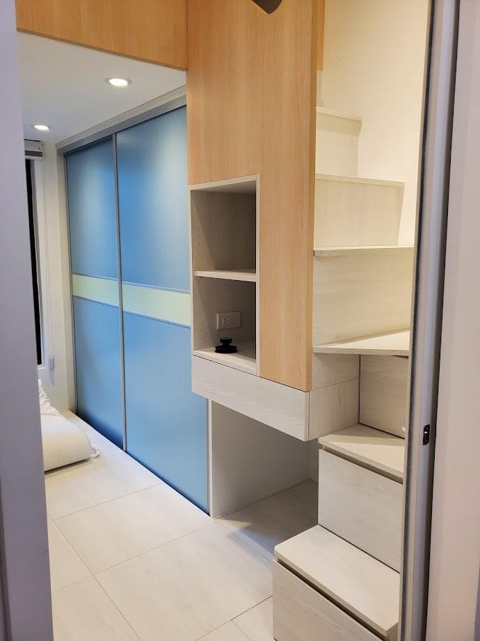 這張照片是一個現代化的臥室,其中最顯眼的部分是房間右邊的梯子,它以白色和木色為主,設計簡單大方,與房間整體風格相得益彰。