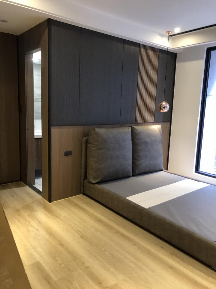 1) 照片顯示一個帶有灰色床頭板的現代臥室,房間裡有一個大窗戶和一個吊燈