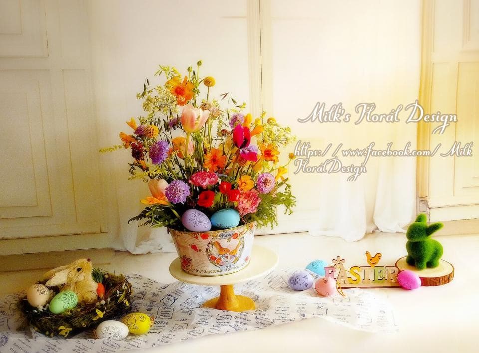 1) 照片展示一個花瓶裡的鮮花,花瓶上有一隻兔子和一些彩蛋